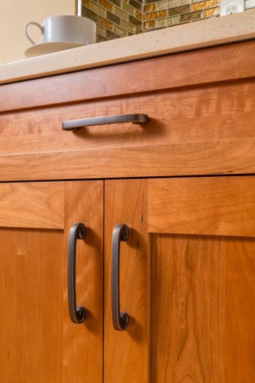 wood tone cabinets and drawer front with brushed bronze cabinet hardware