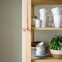 Dish and decorations on open wooden shelves in white kitchen