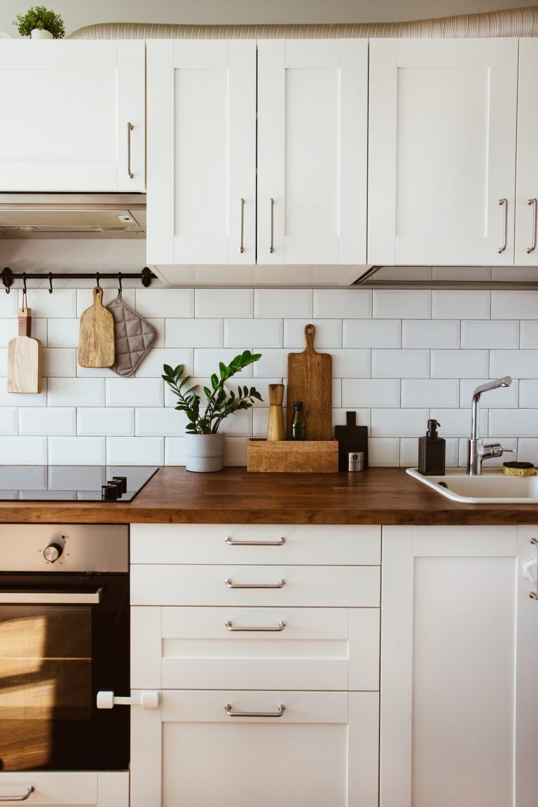 Kitchen brass utensils, chef accessories. Hanging kitchen with white tiles wal