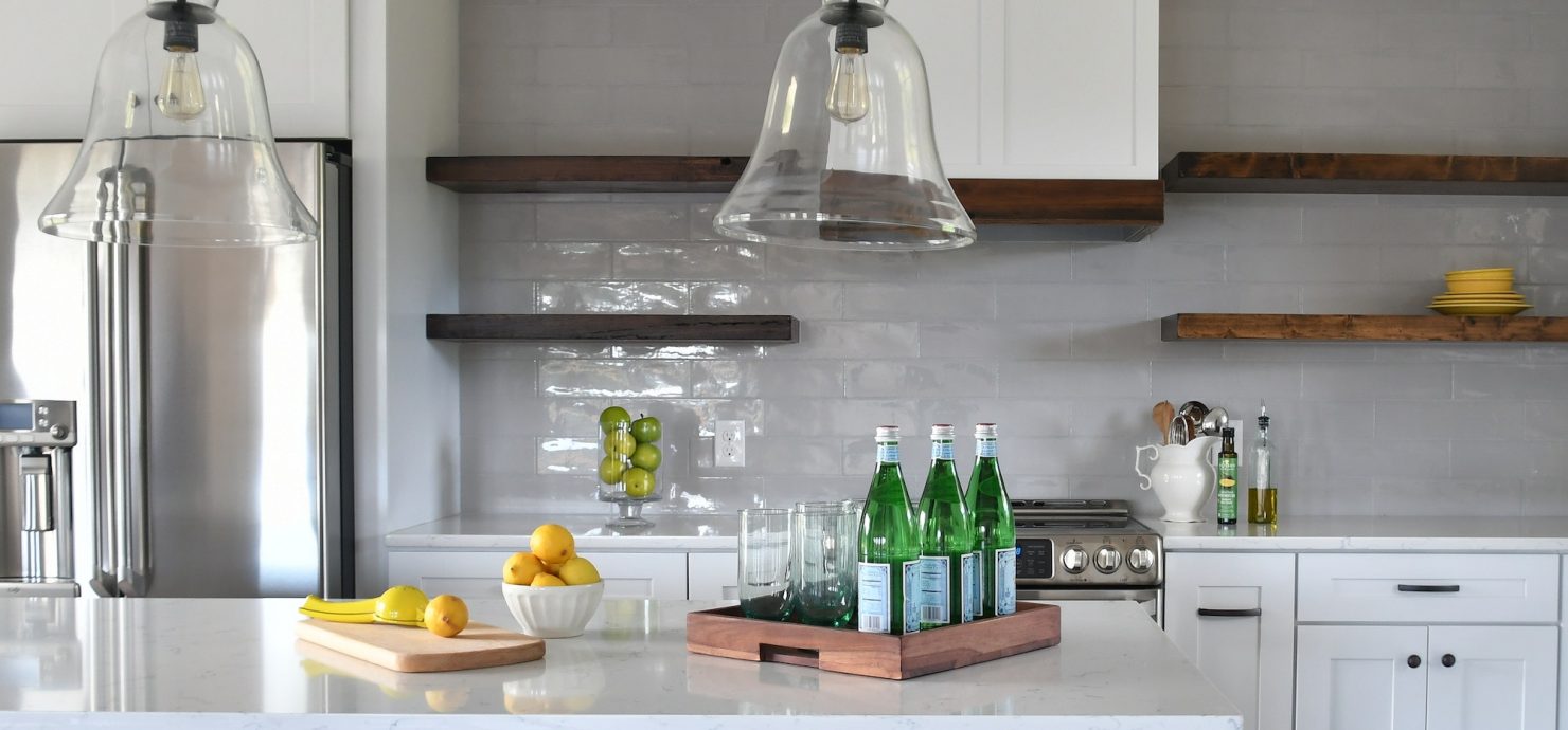 Kitchen in a new home with open concept layout, white counters cabinets floating wood shelves