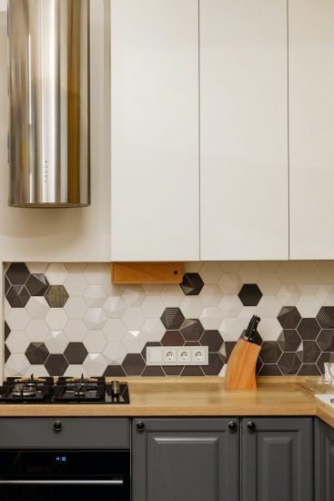 Modern kitchen interior with hood with white and gray cabinets, mixed style