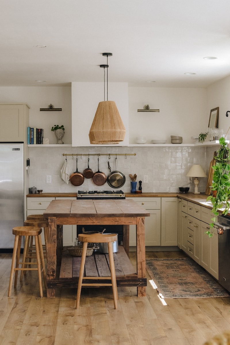 brown wooden seat beside white wooden kitchen cabinet